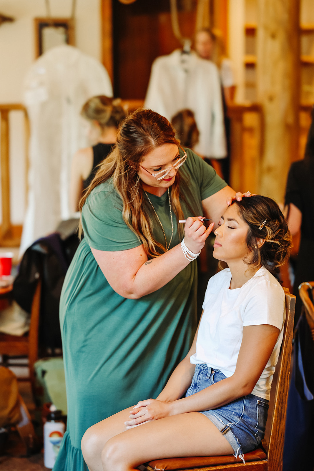 Woman putting makeup on bride for Rocky Mountain Bride Styled Editorial