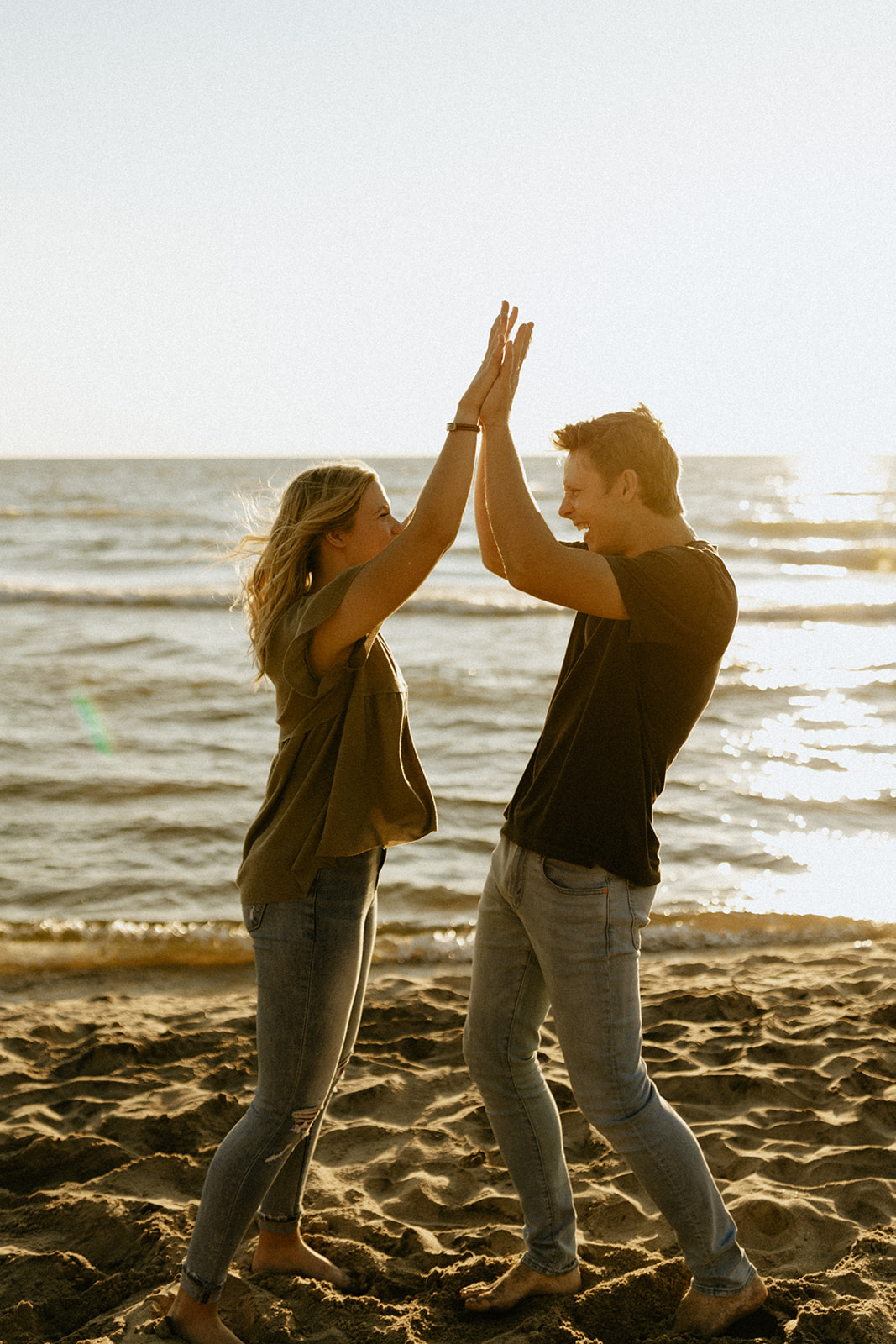 A couple high fiving at Saugatuck Dunes State Park in Michigan