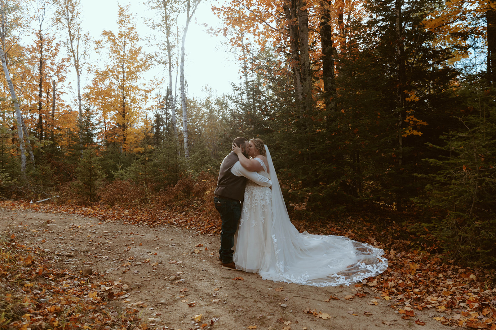 Outdoor Fall bridal portrait in the leaves with the bride and groom.