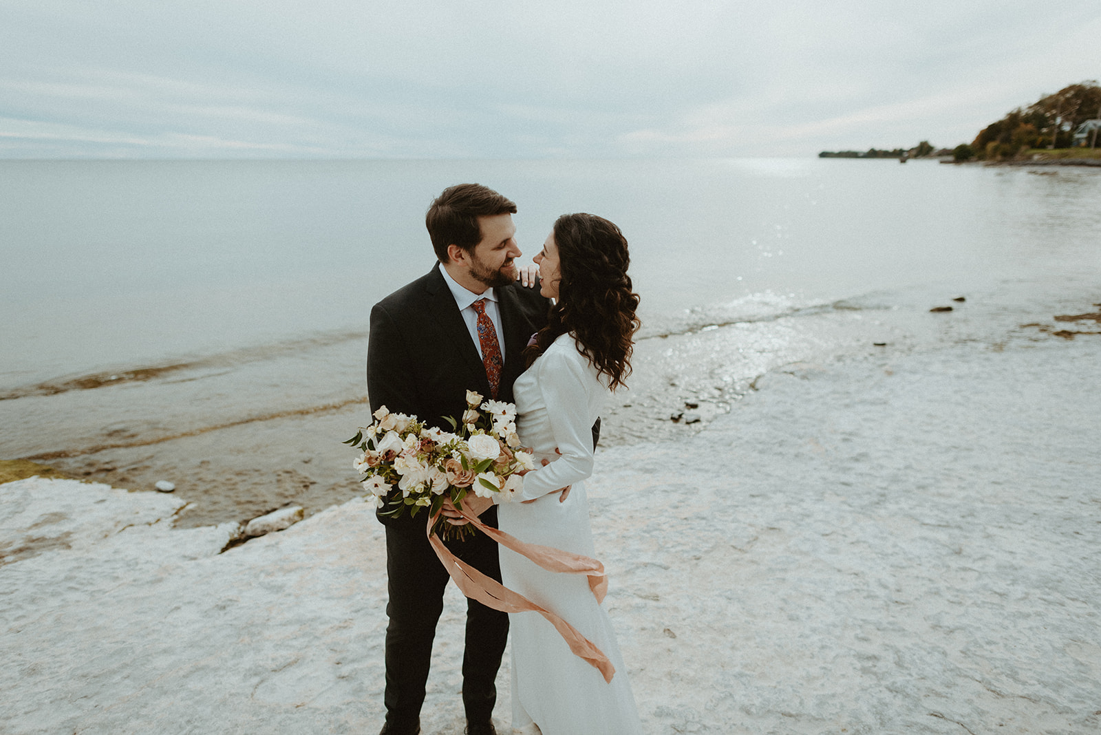 Newlyweds exploring rocky beaches outside Drake Devonshire in Prince Edward County.