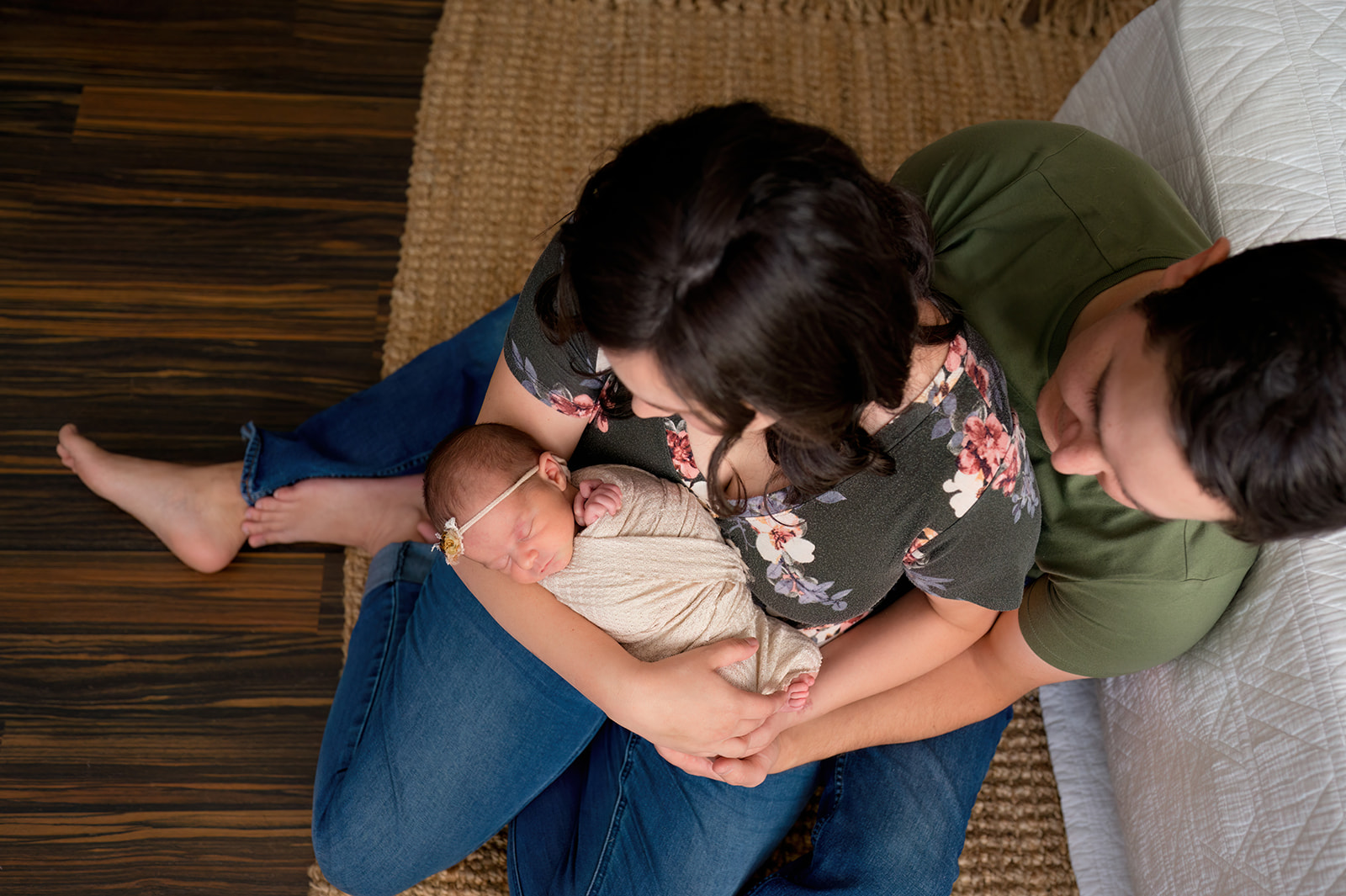 overhead view of parents holding newborn baby girl in loveland photography studio