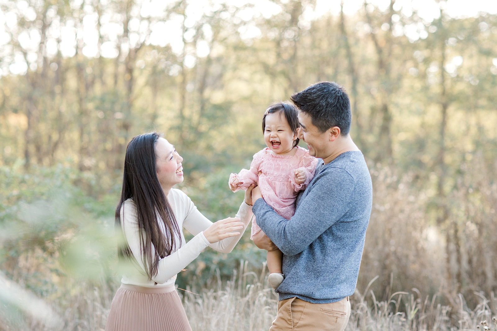 Family looks at each other lovingly and laughs during family photoshoot in Toronto, Ontario