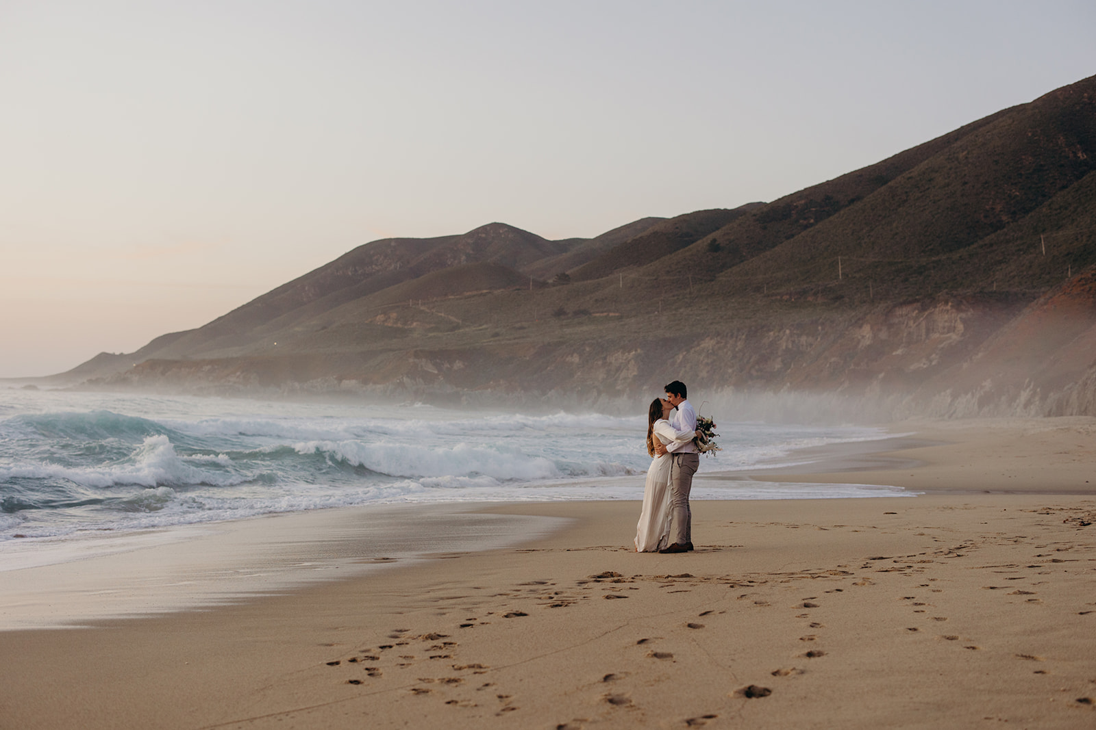 a bride and groom on the beach in Big Sur