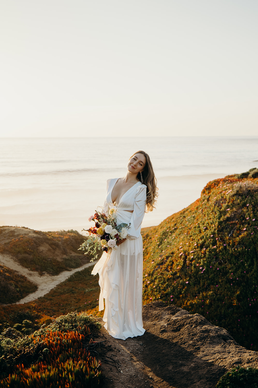 bride in a wedding dress with her bouquet at Garapata State Park