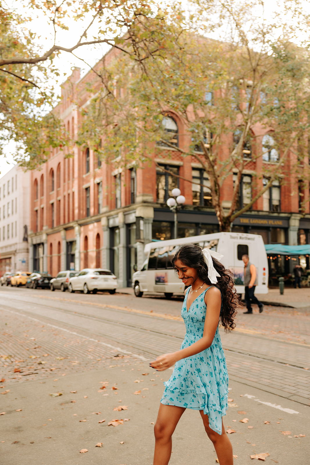 A girly photo of an ethnic high school senior girl crossing the sidewalk in Pioneer Square, Seattle.