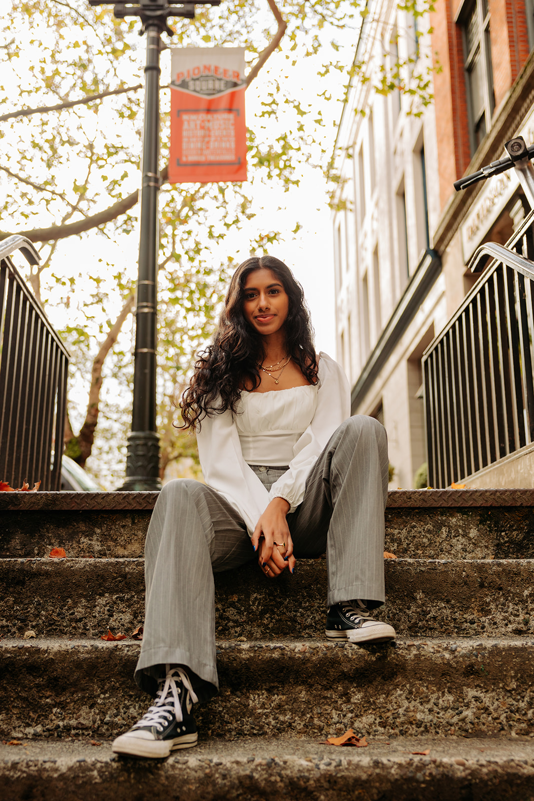 An edgy photo of an ethnic high school senior girl posing on concrete steps in Pioneer Square, Seattle.
