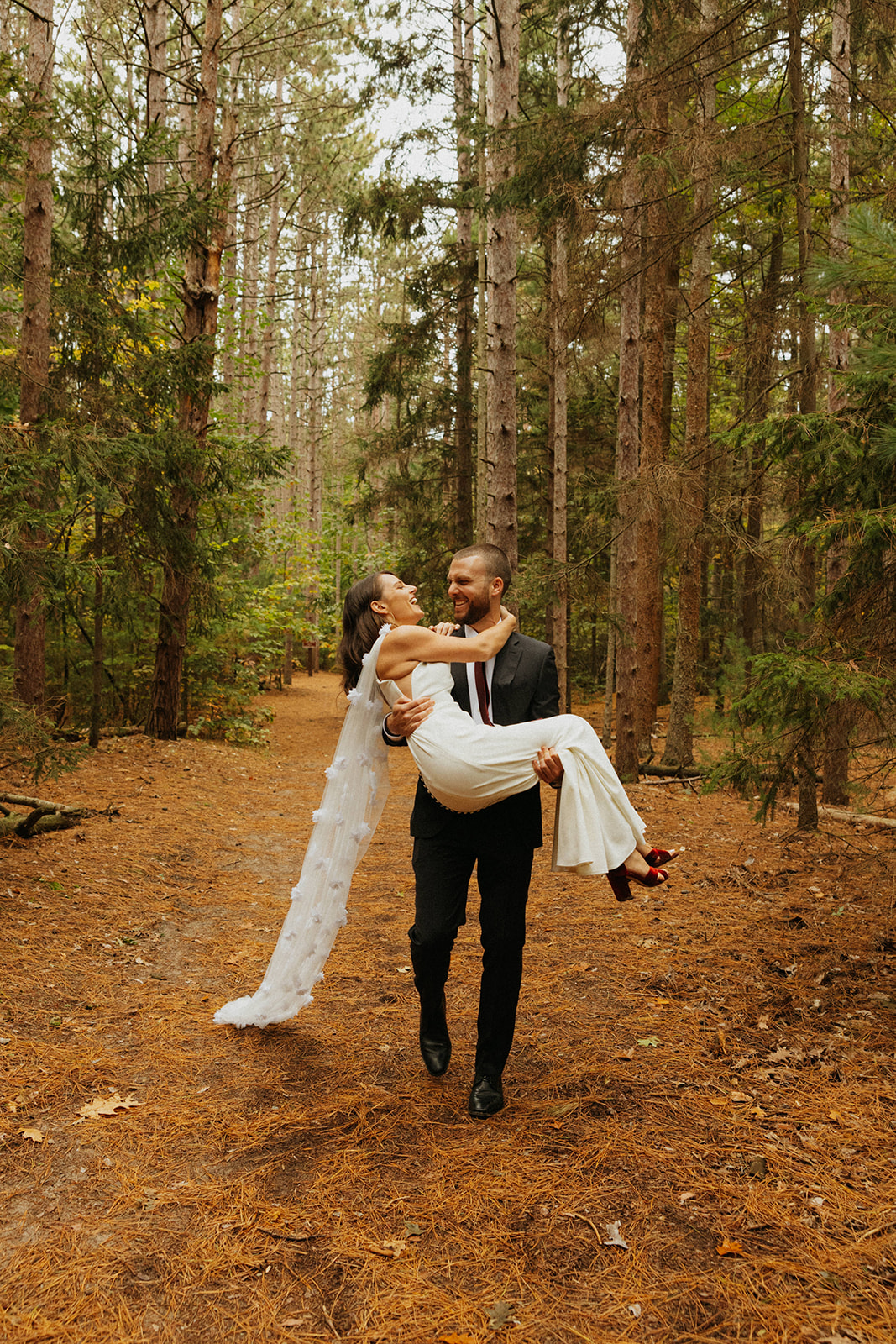 Bride and groom in a wooded forest in west Michigan on Lake Michigan beach.