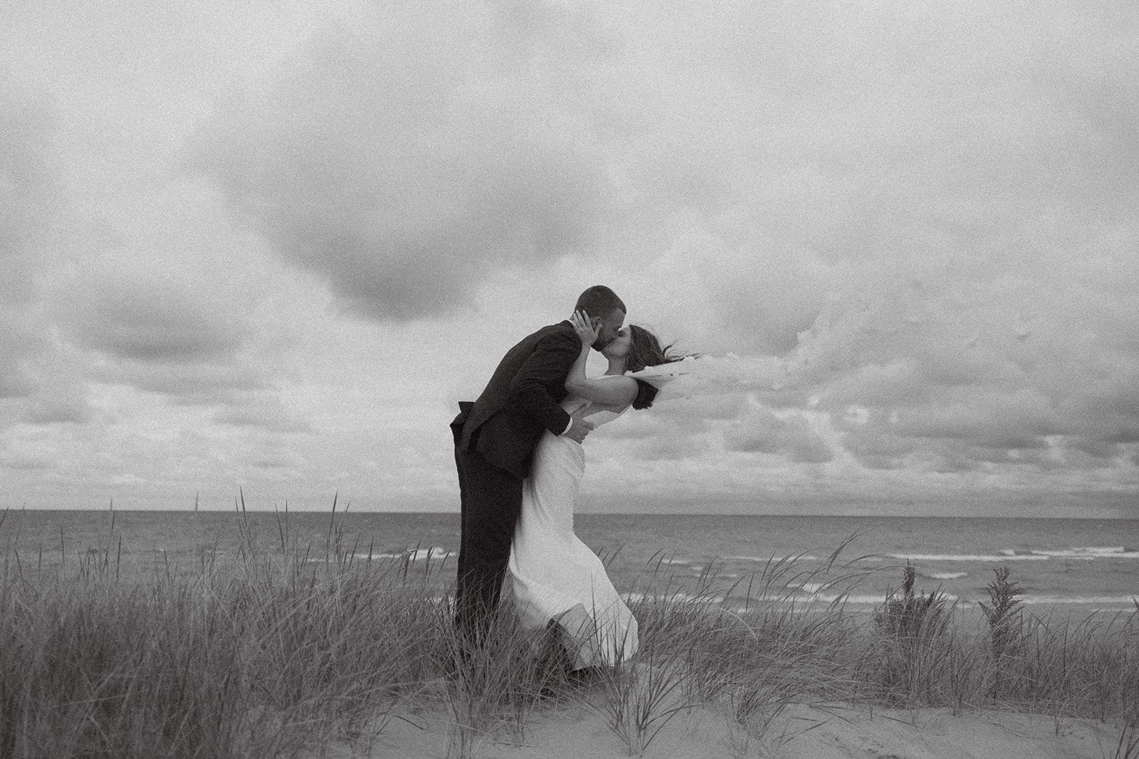 Bride and groom walking on the beach alongside Lake Michigan for their Grand Rapids wedding.