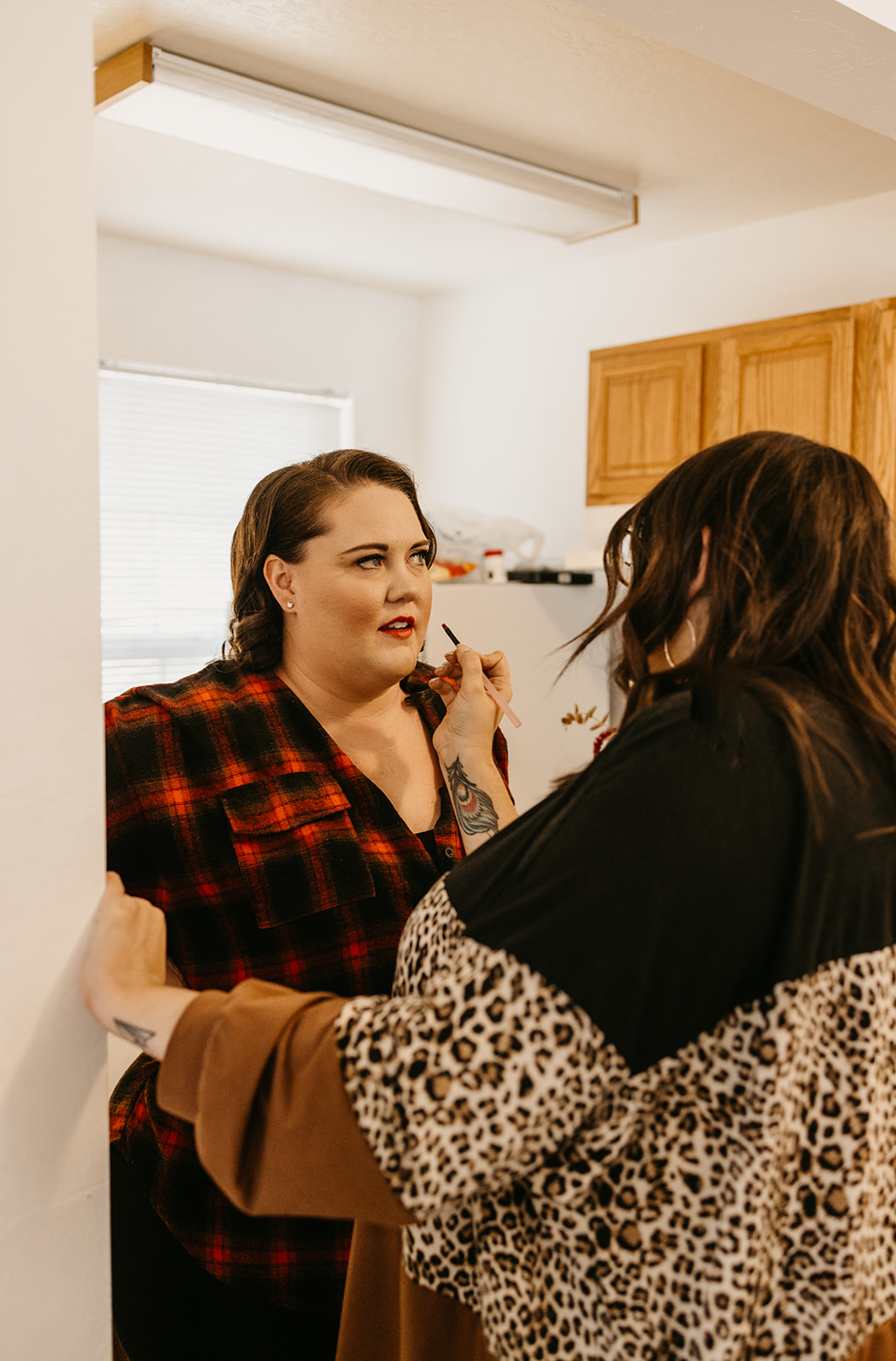 a bridesmaids lipstick is being touched up by a make up artist
