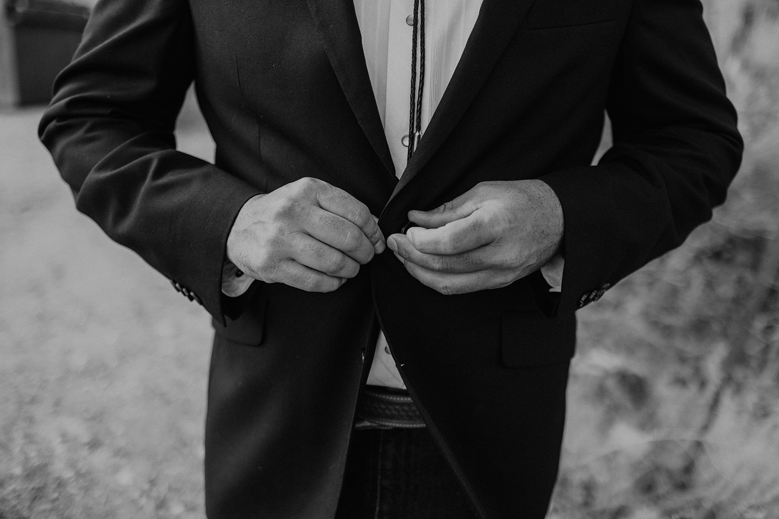 groom buttoning his jacket