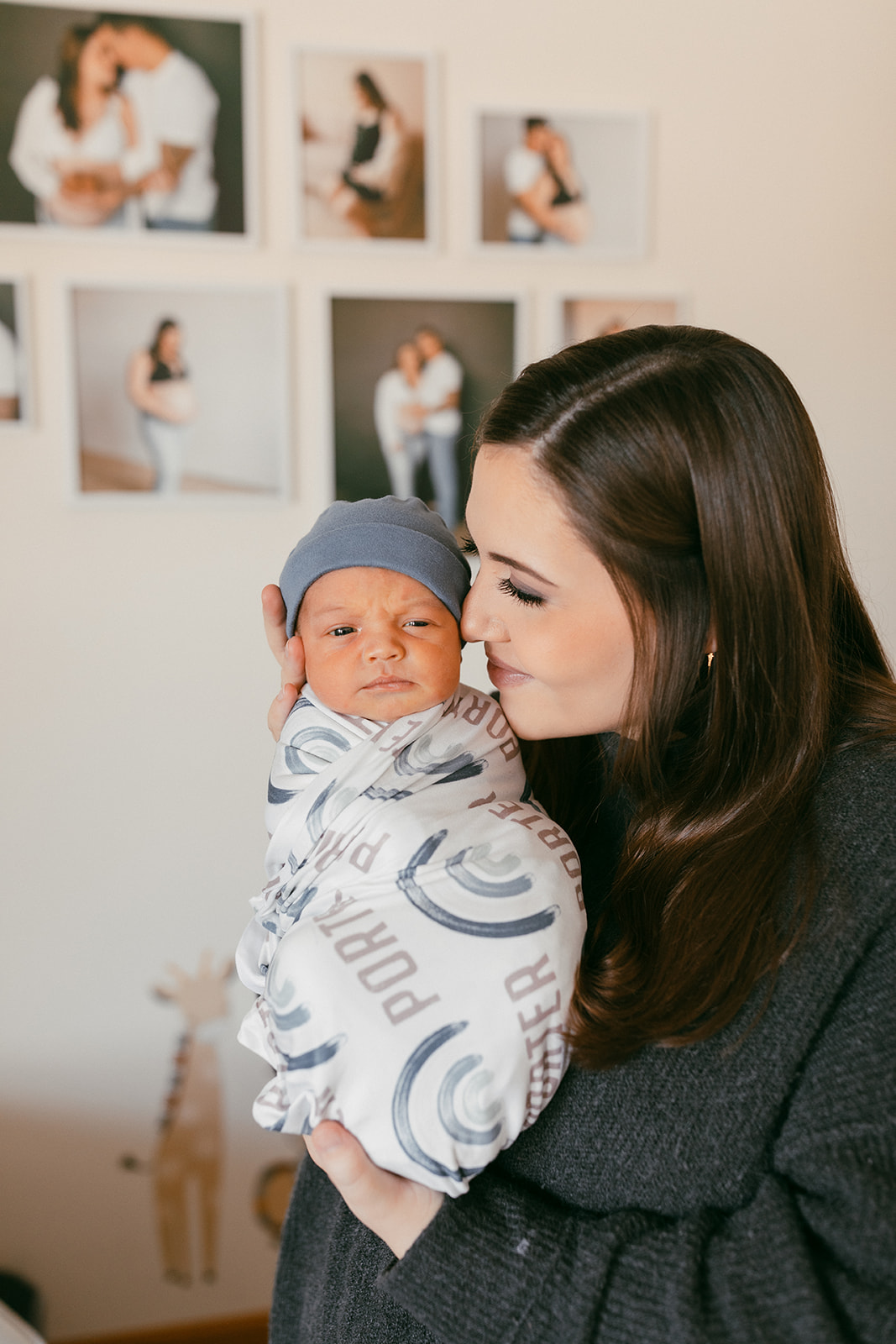 mom holding baby in the nursery during in-home newborn family photo session. 
