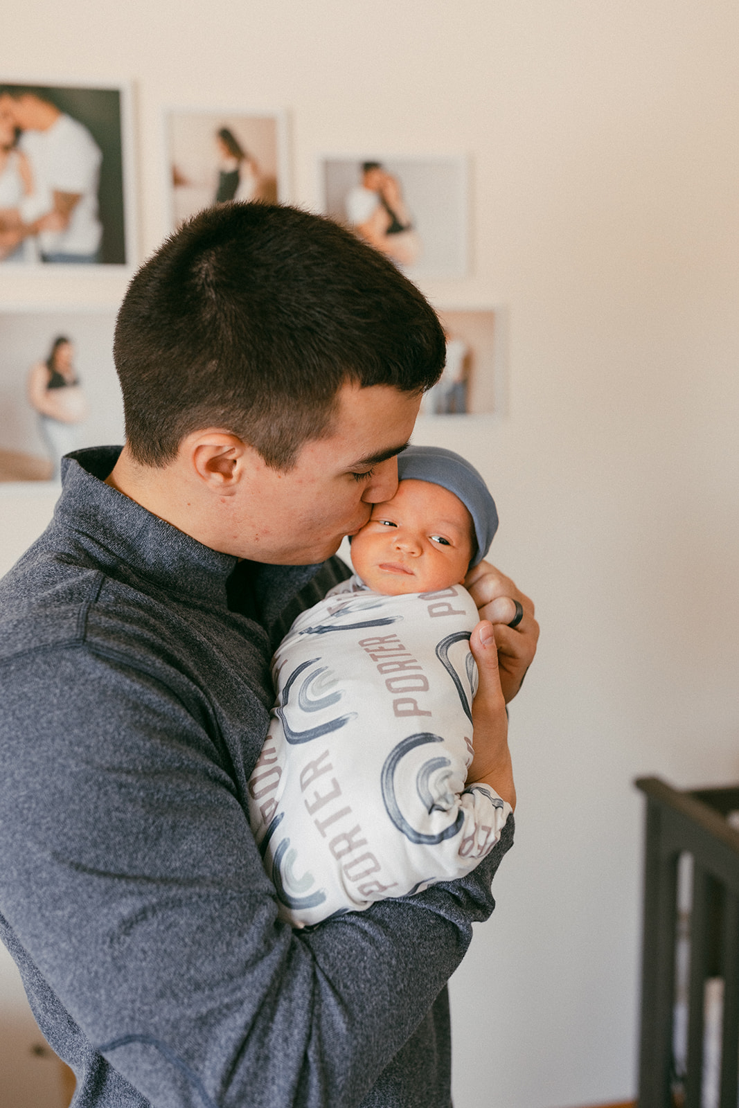 dad holding baby in the nursery during in-home newborn family photo session. 
