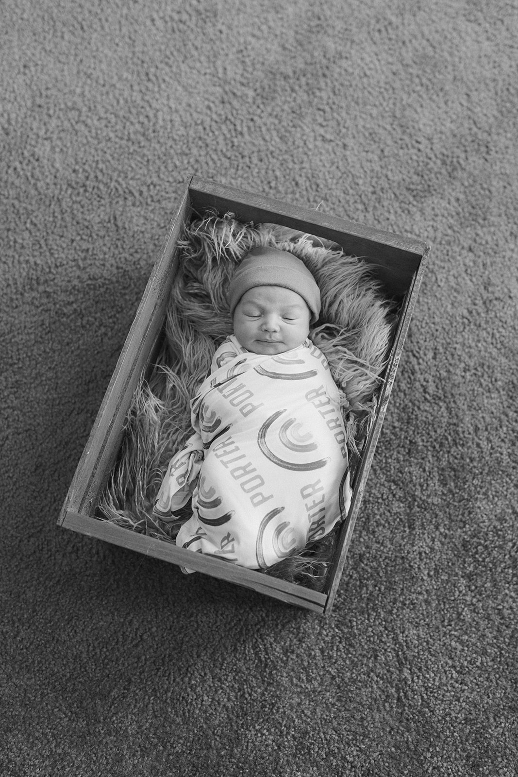 newborn baby in his crib in the nursery during in-home newborn family photo session. 