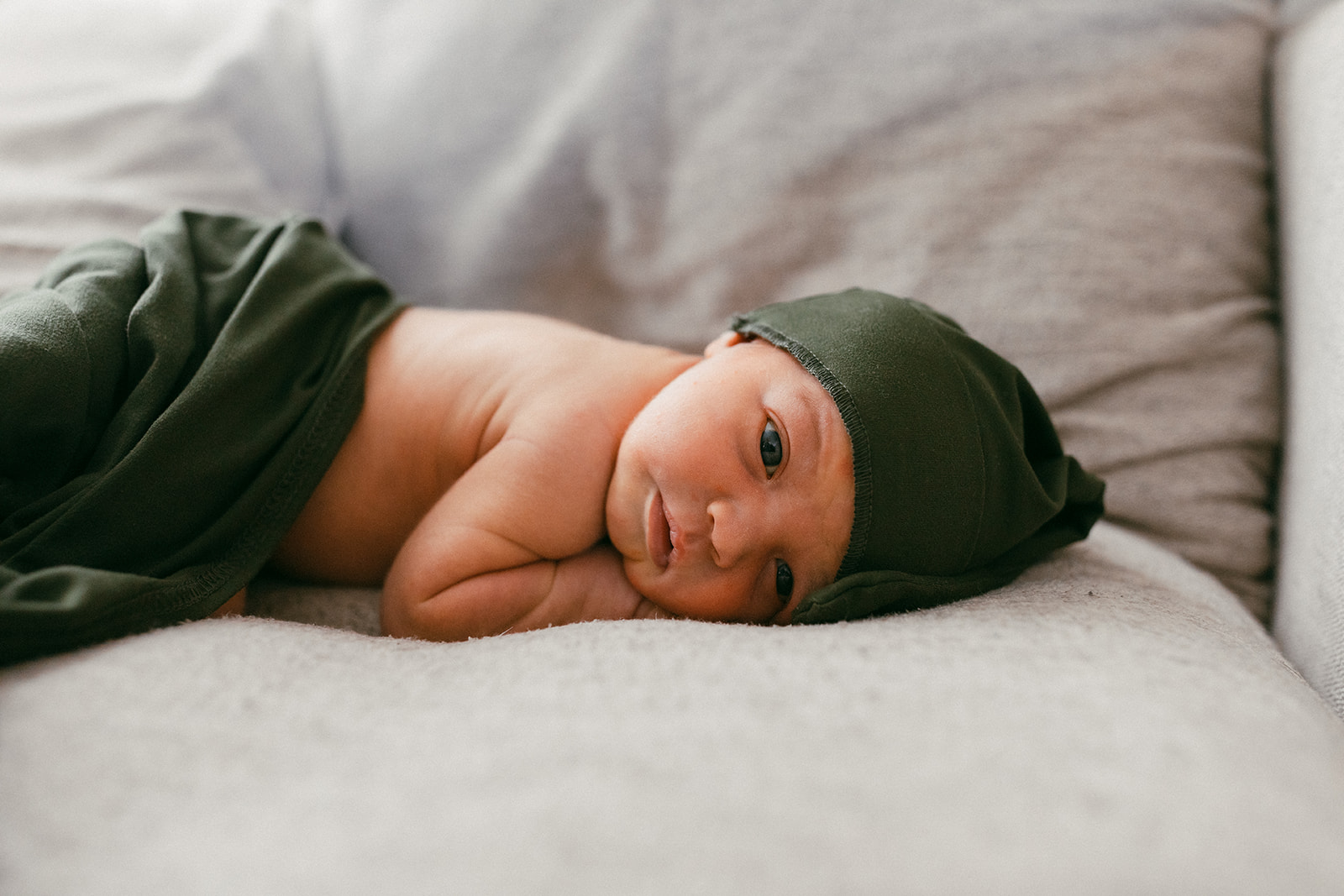 newborn baby in his crib in the nursery during in-home newborn family photo session. 