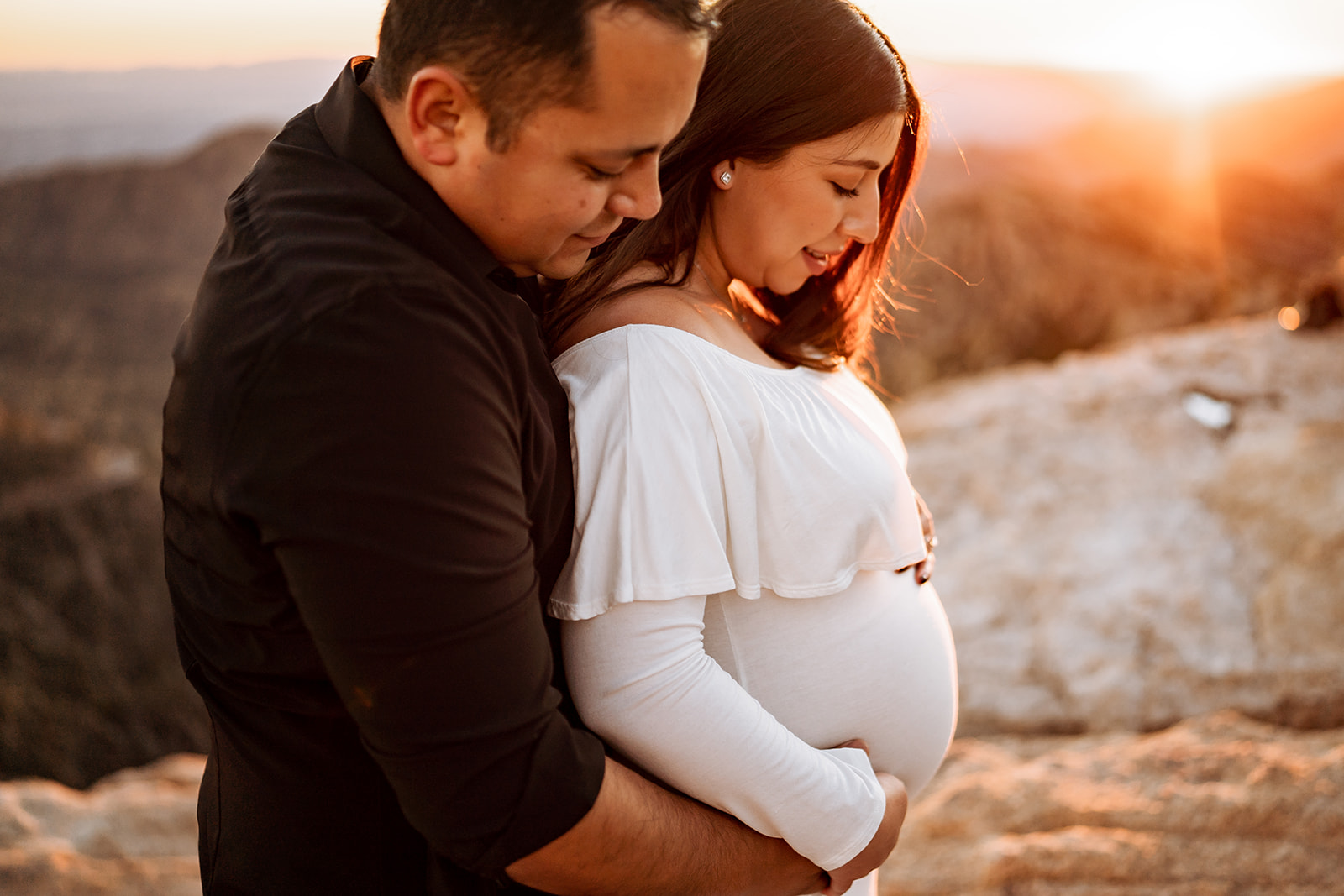 a couple taking maternity photos at sunset at Mount Lemmon