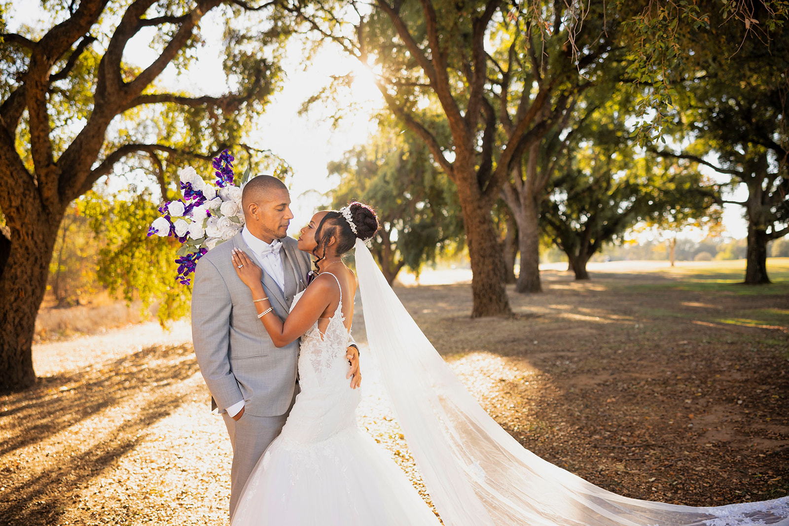 a couple who is posed for their post wedding couples portrait session at the pavilion at haggin oaks near trees