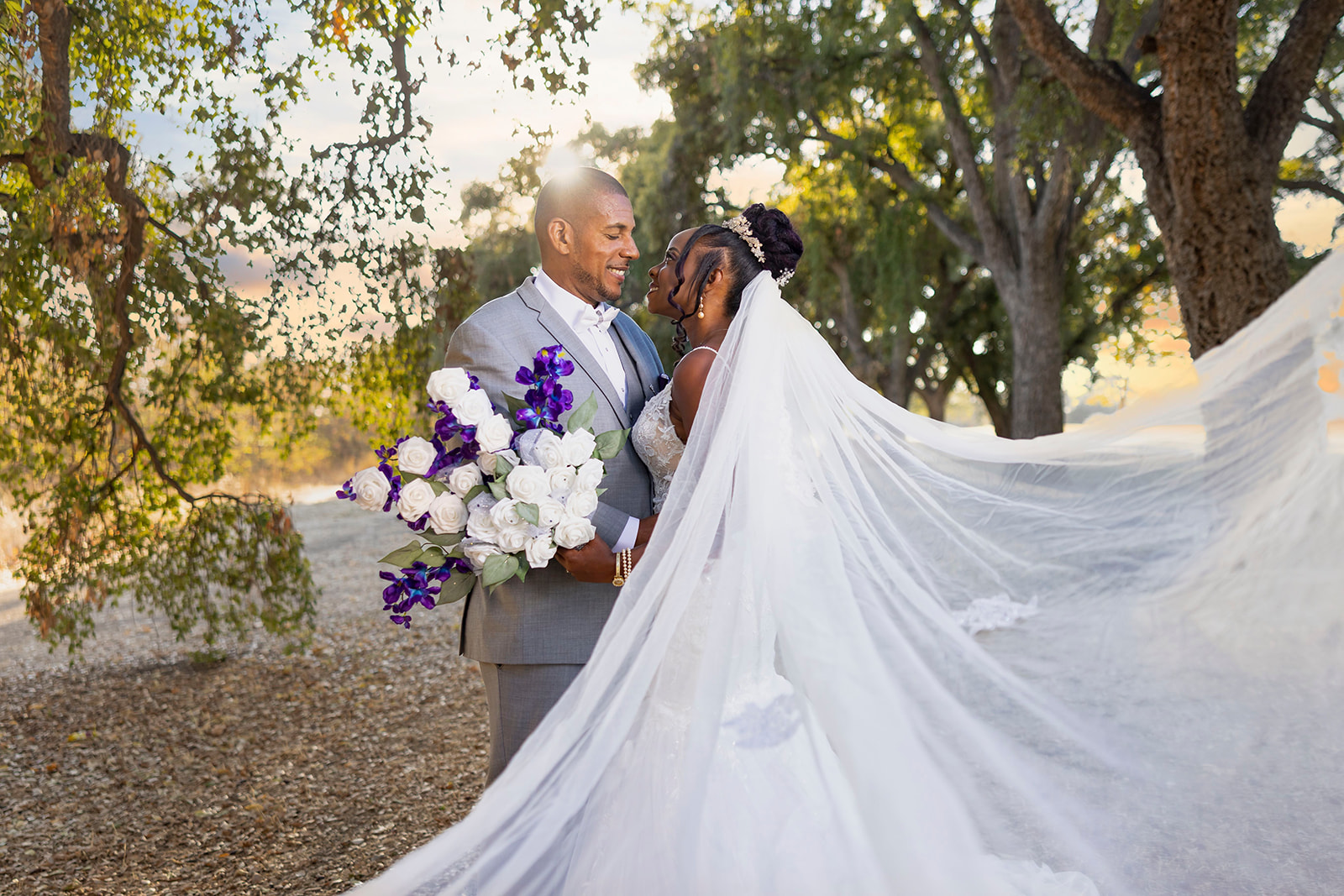 a landscape picture of the brides veil and the couple kissing at their post wedding couples portrait session