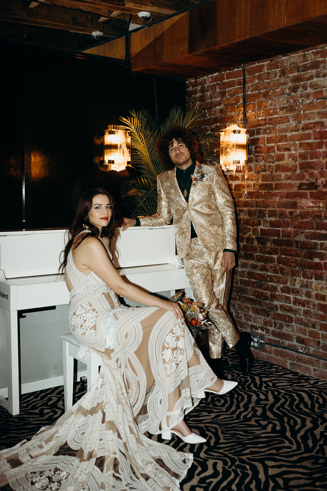 couple standing by white piano inside bourbon room