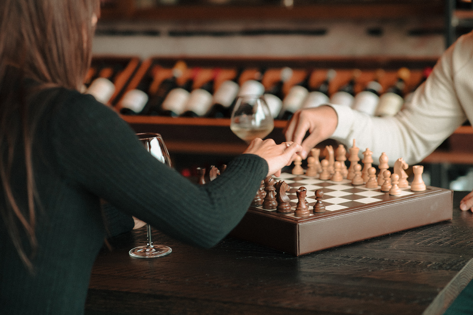 Couple playing chess at a wine bar