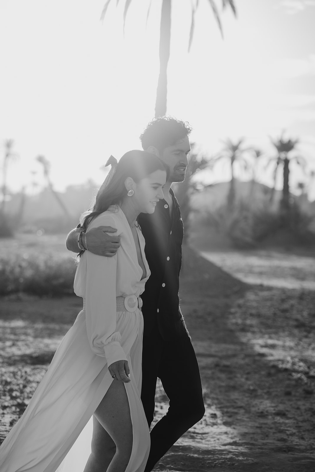 A couple who eloped in Marrakech walk in the Moroccan dessert at sunrise
