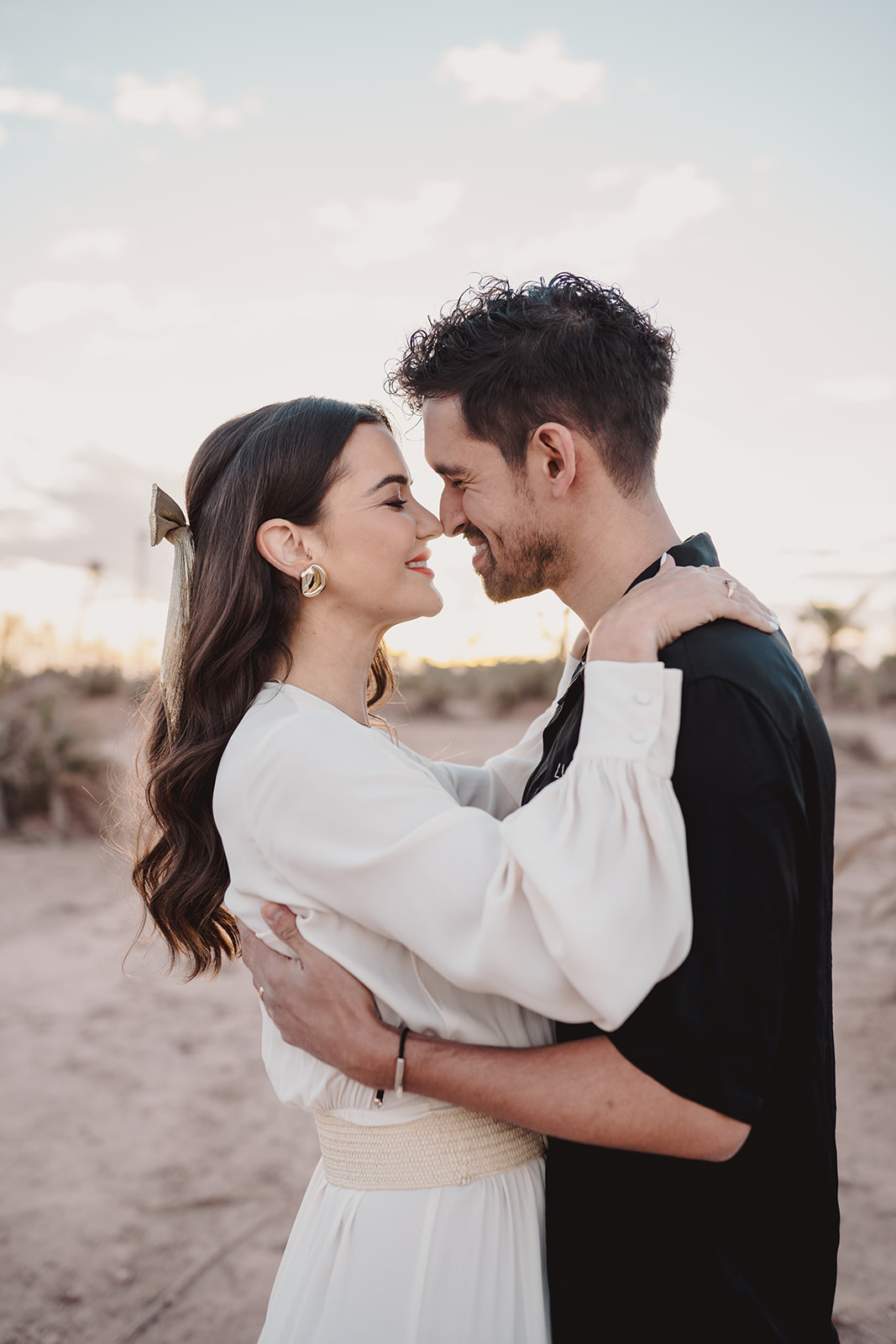A couple who eloped in Marrakech stand in the Moroccan dessert at sunrise