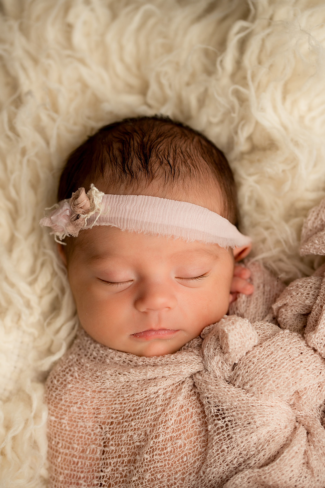 Studio portrait of newborn baby girl in cream and nude pinks