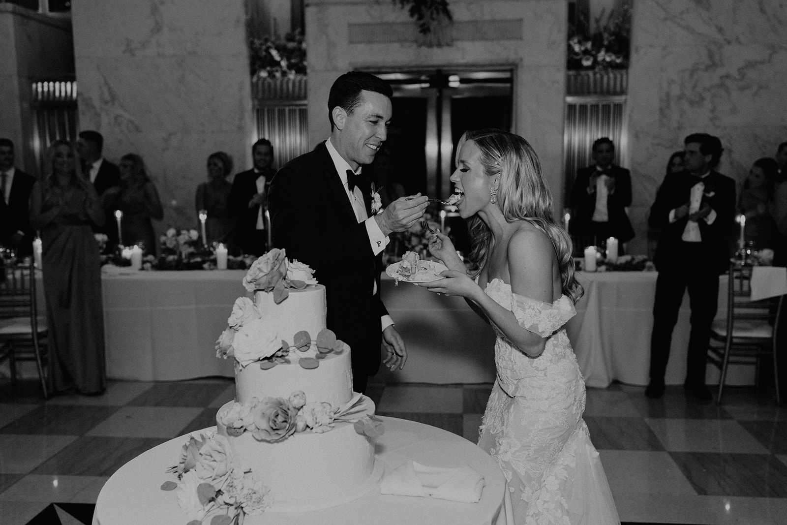 A couple share their fist bite of cake at their downtown chicago wedding 