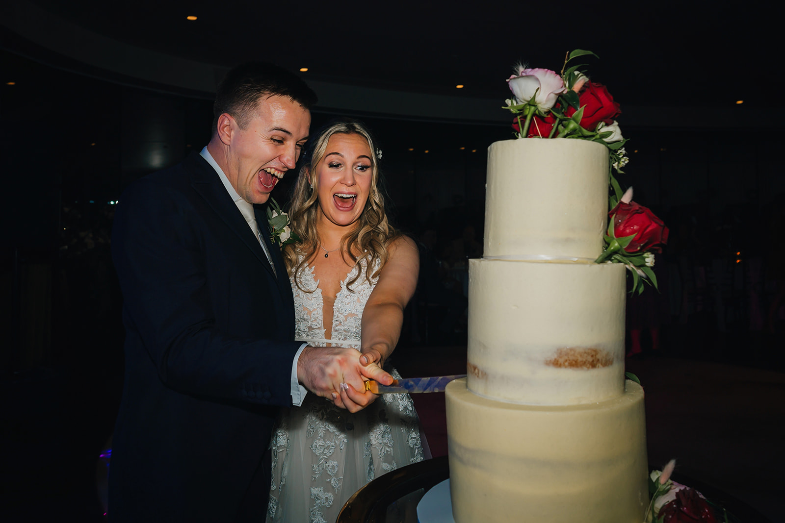 the newly-weds cut their wedding cake