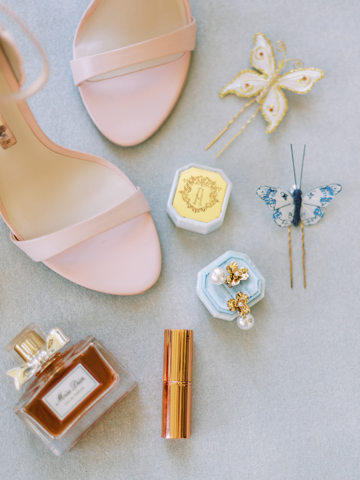 golden wedding details ginko leaf gold pearl earrings blue wedding invitation pink flowers pink heel butterfly decor 