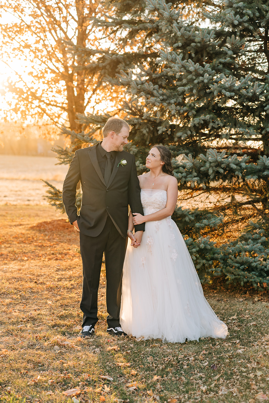 A bride and groom embrace in the golden hour light of a sunset in Minnesota