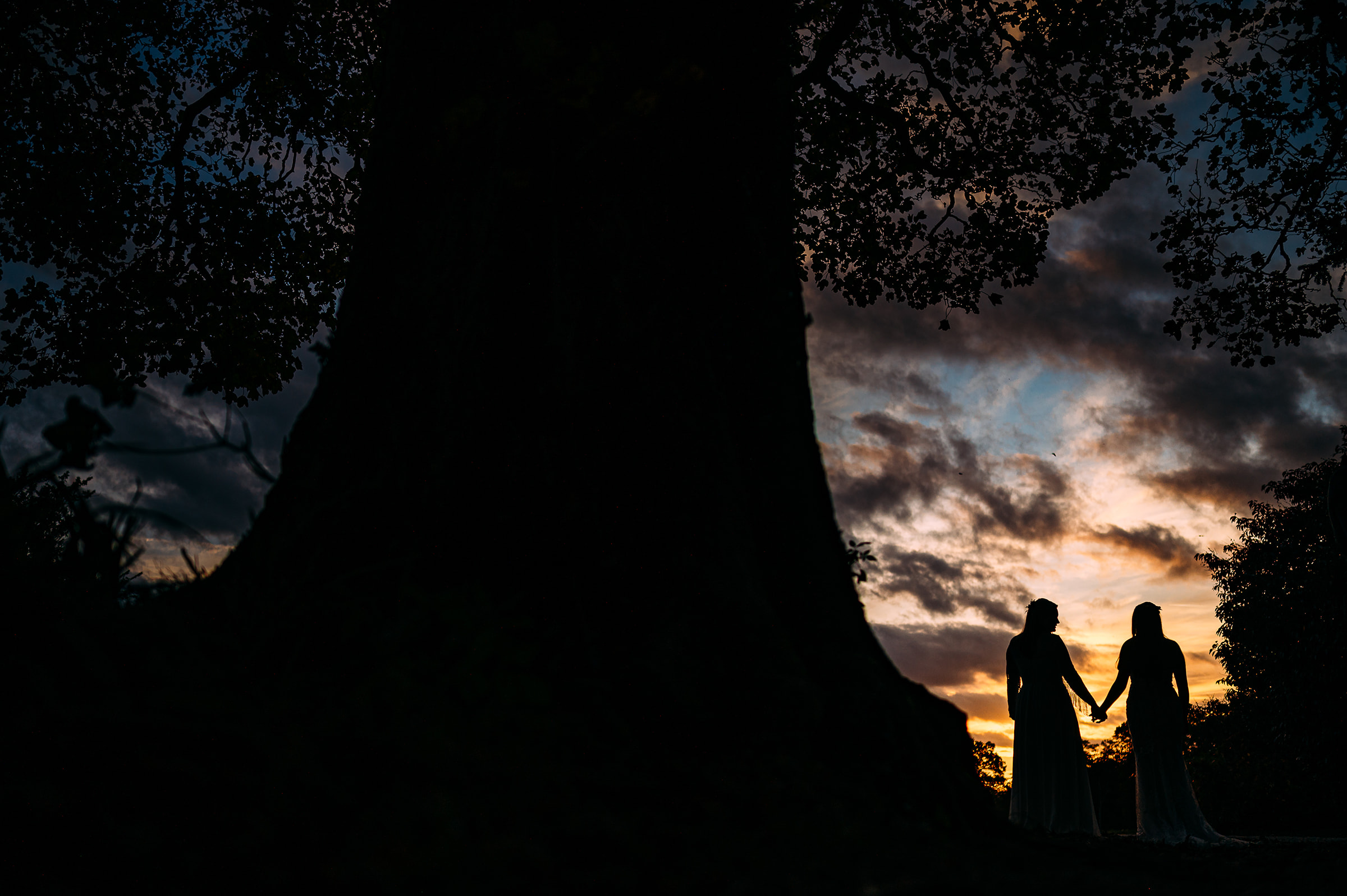 Sunset silhouette of two brides