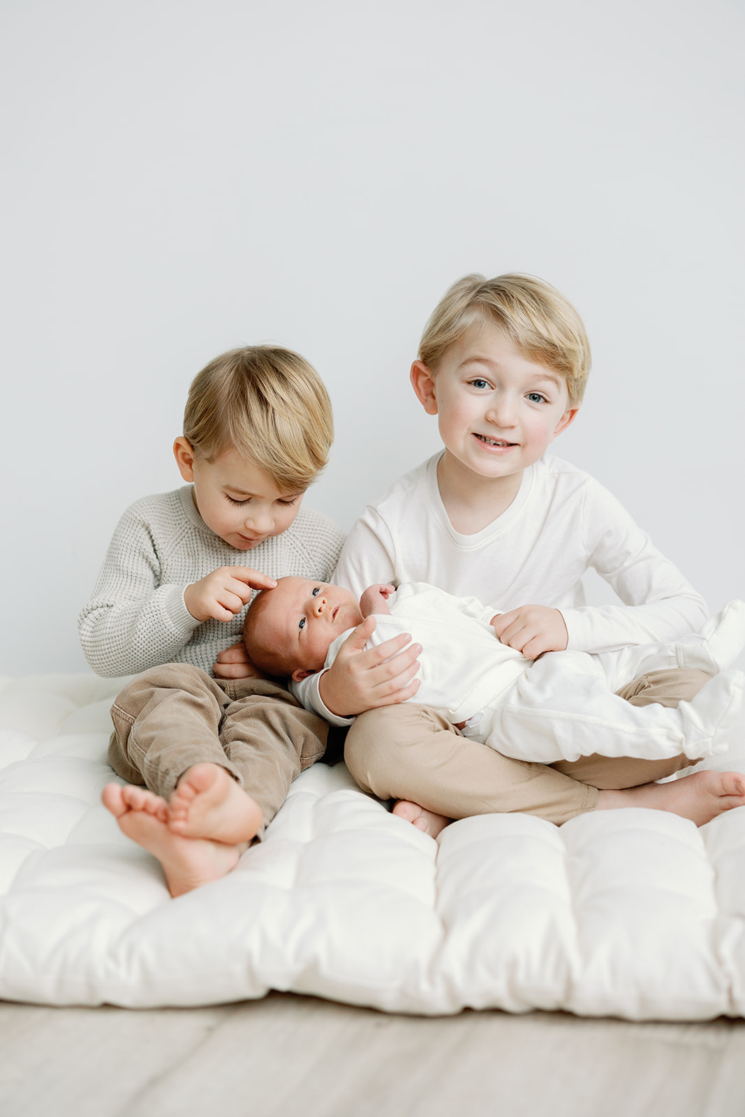 Brothers holding newborn