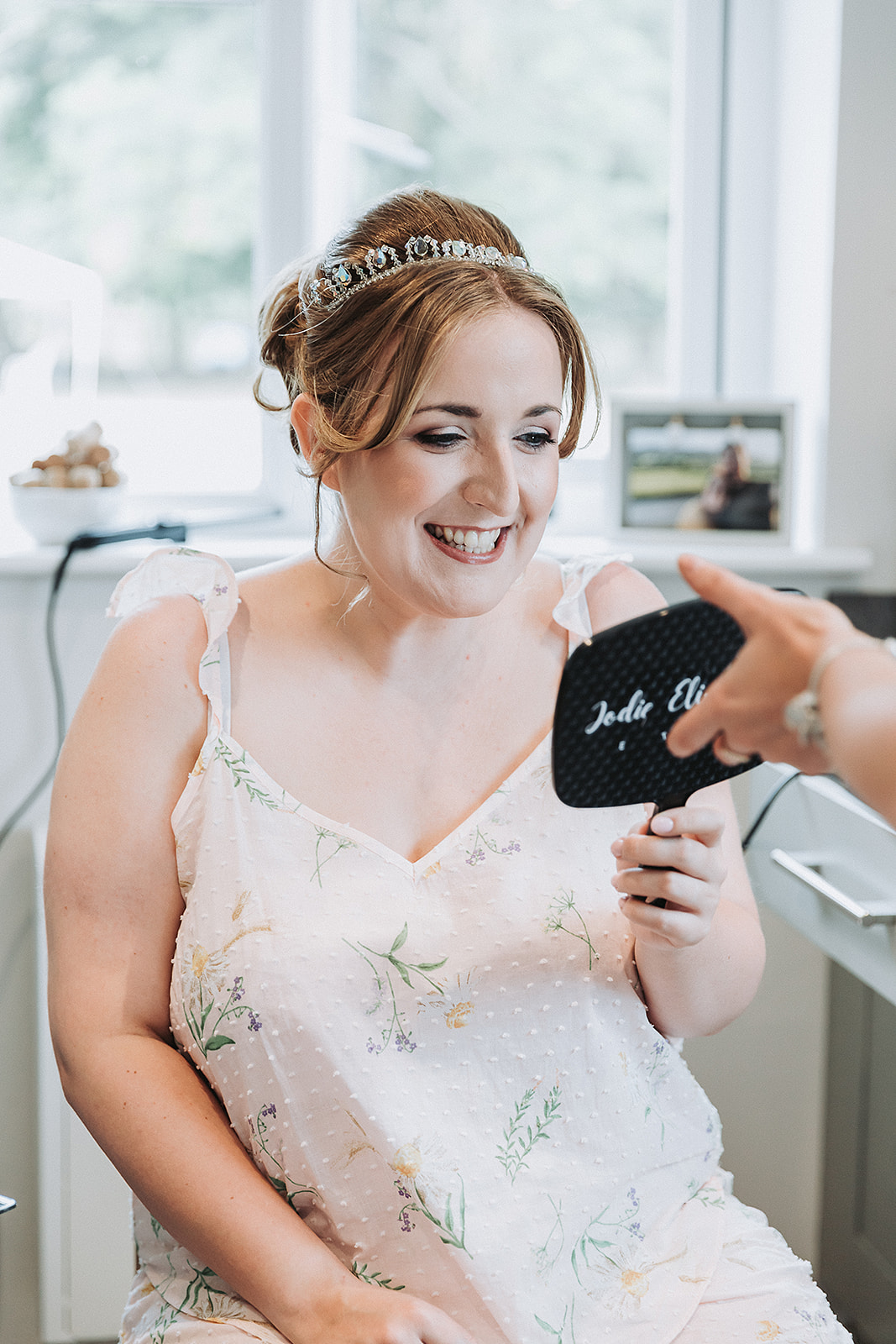 Bride smiling in the mirror at her hair and make up. Wedding Photo by Perfect Memories Photography