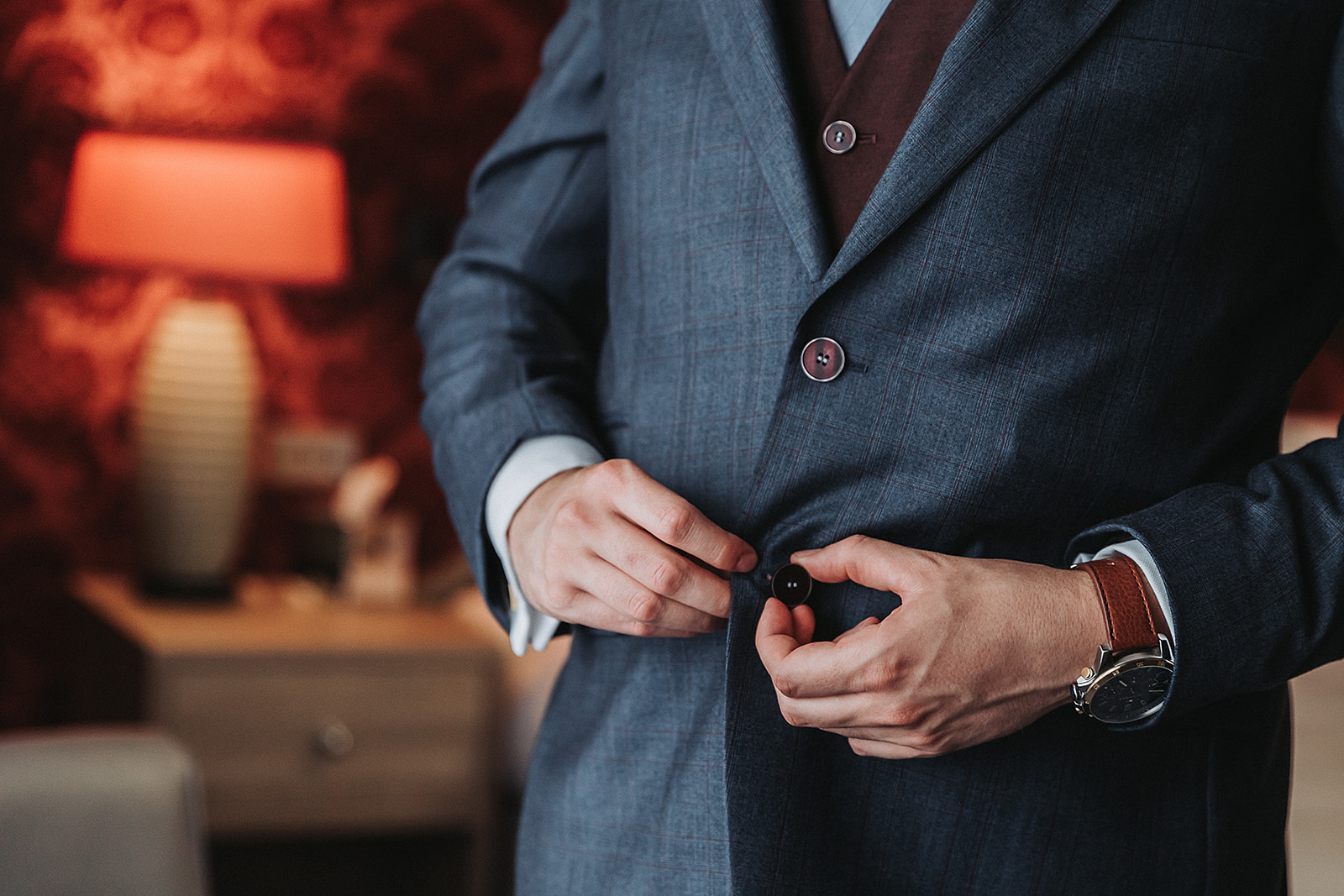 Groom buttoning up his suit at Pendley Manor, Tring. Wedding Photo by Perfect Memories Photography
