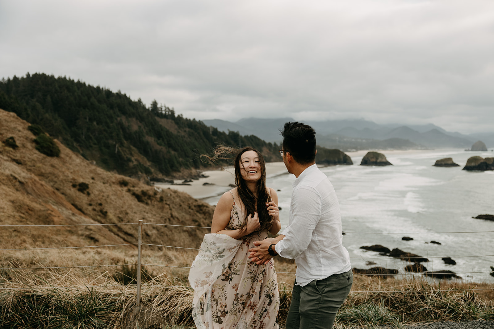 A couple overlooking Crescent Beach at Ecola State Park at the Oregon Coast