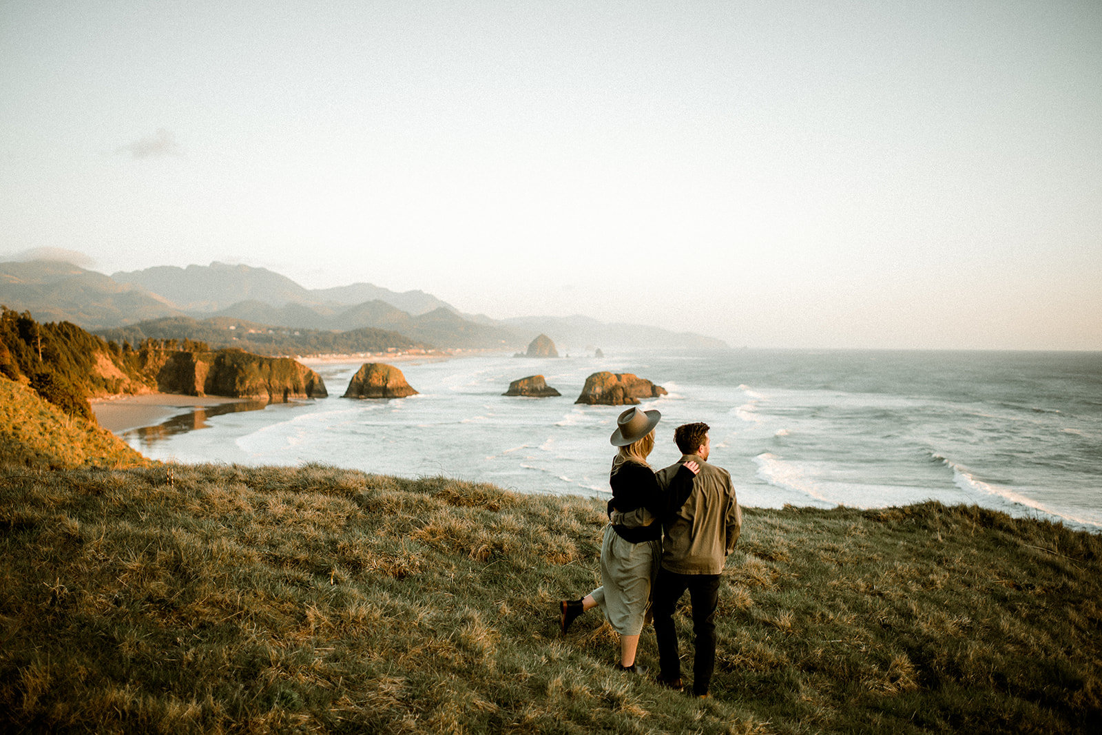 A couple at sunset with views of Cannon Beach and Haystack Rock at their Northern Oregon Coastal Engagement