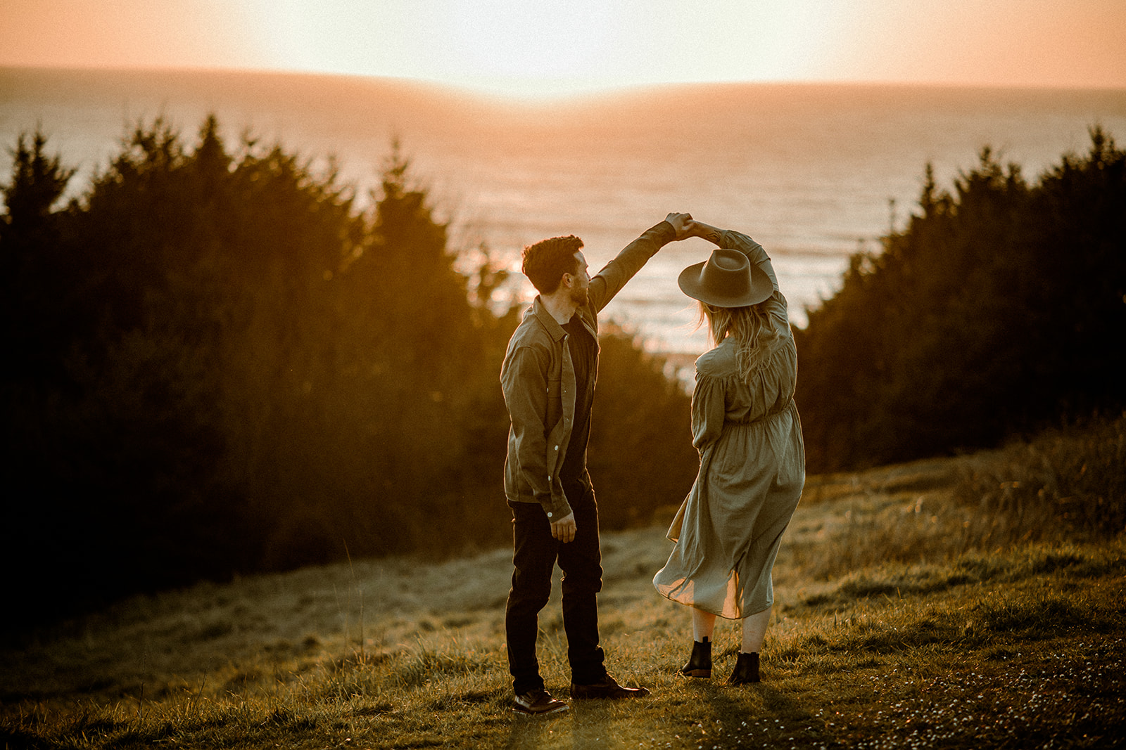 A couple at sunset in golden hour dancing during their Northern Oregon Coastal Engagement
