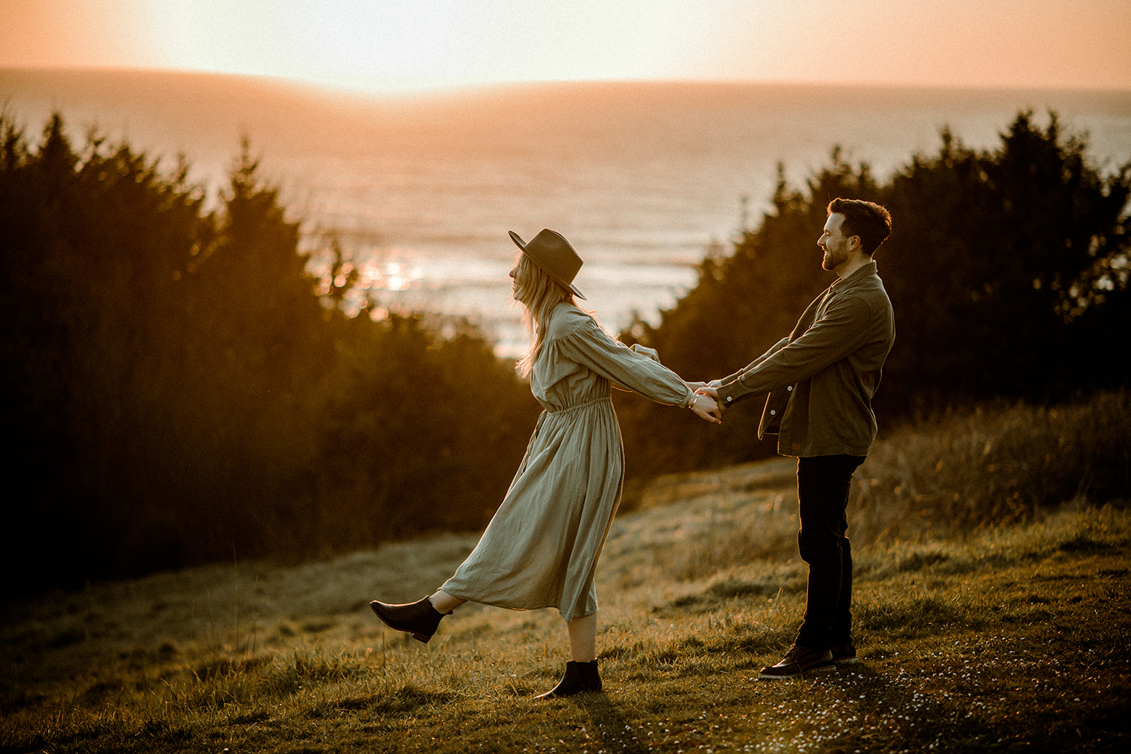 A couple at sunset in golden hour dancing during their Northern Oregon Coastal Engagement