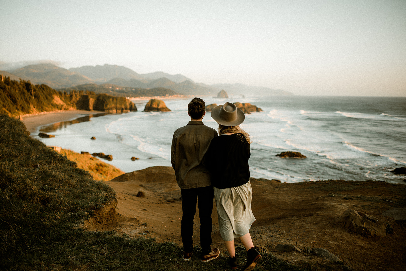 A couple at sunset with views of Cannon Beach and Haystack Rock at their Northern Oregon Coastal Engagement