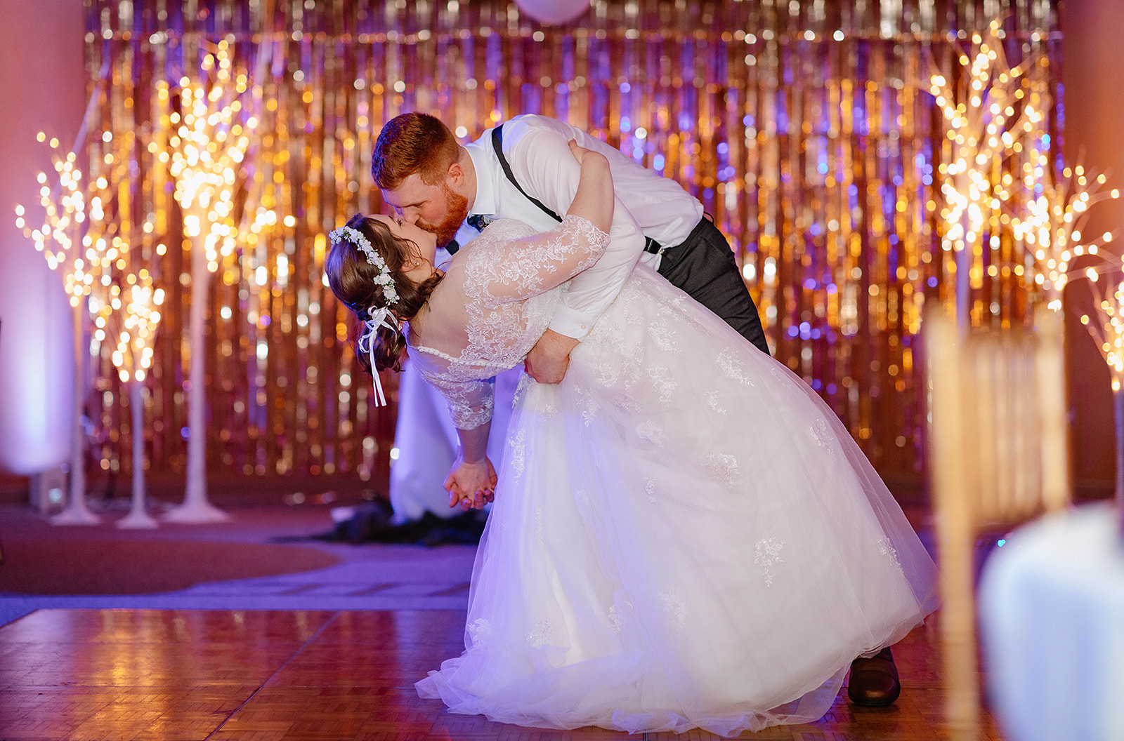Groom dips bride on the dance floor 