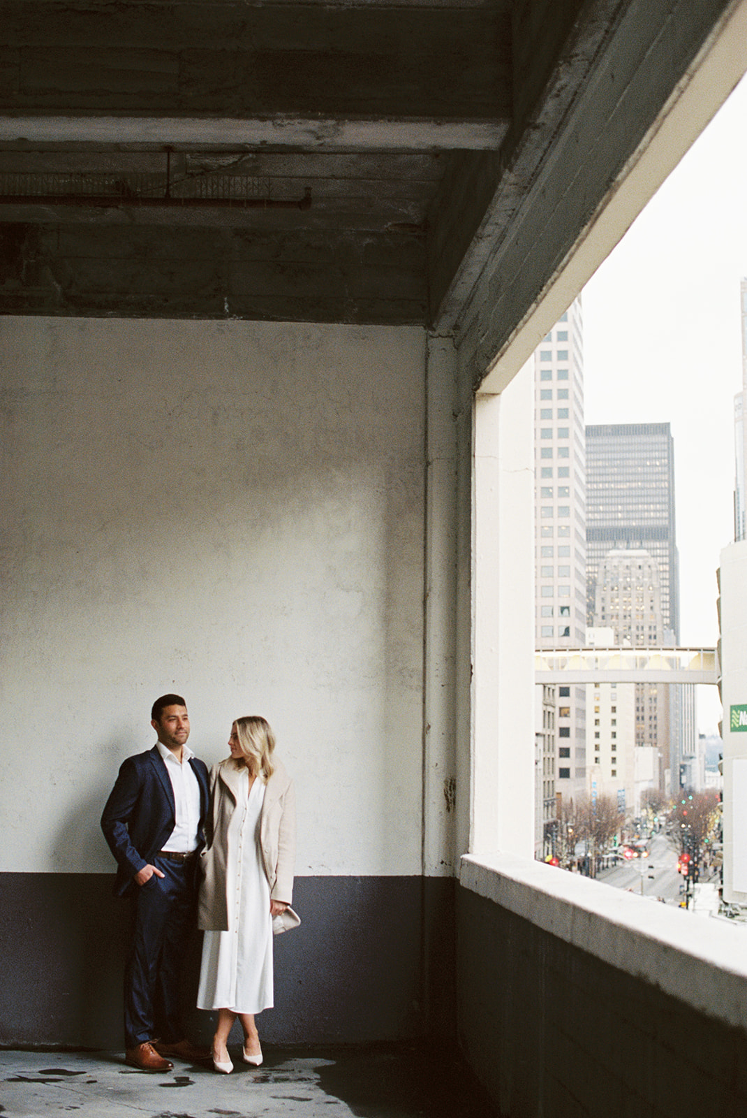 couple stands against a black and white wall during city engagement photo shoot