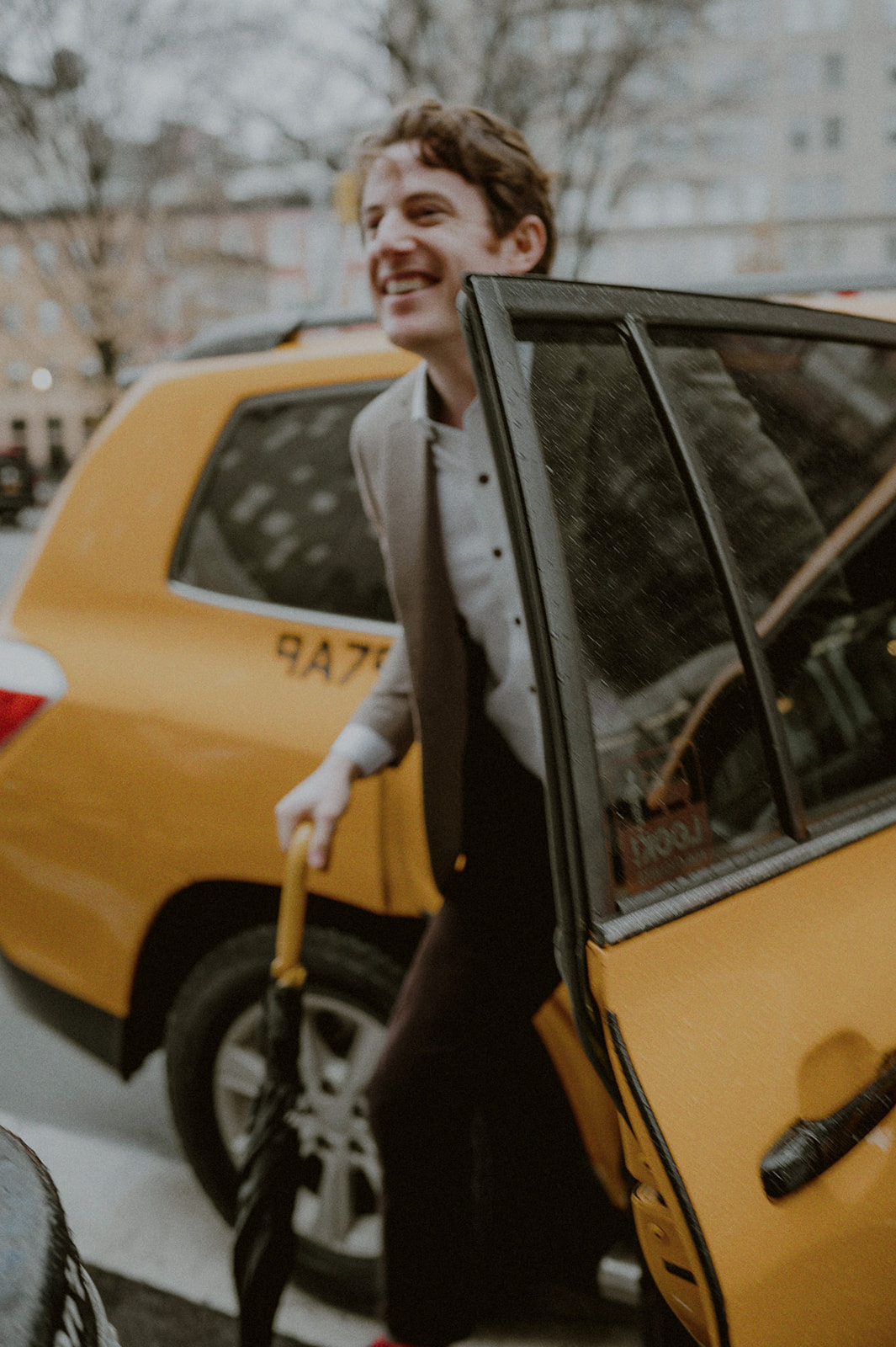 man getting out of taxi cab and grinning