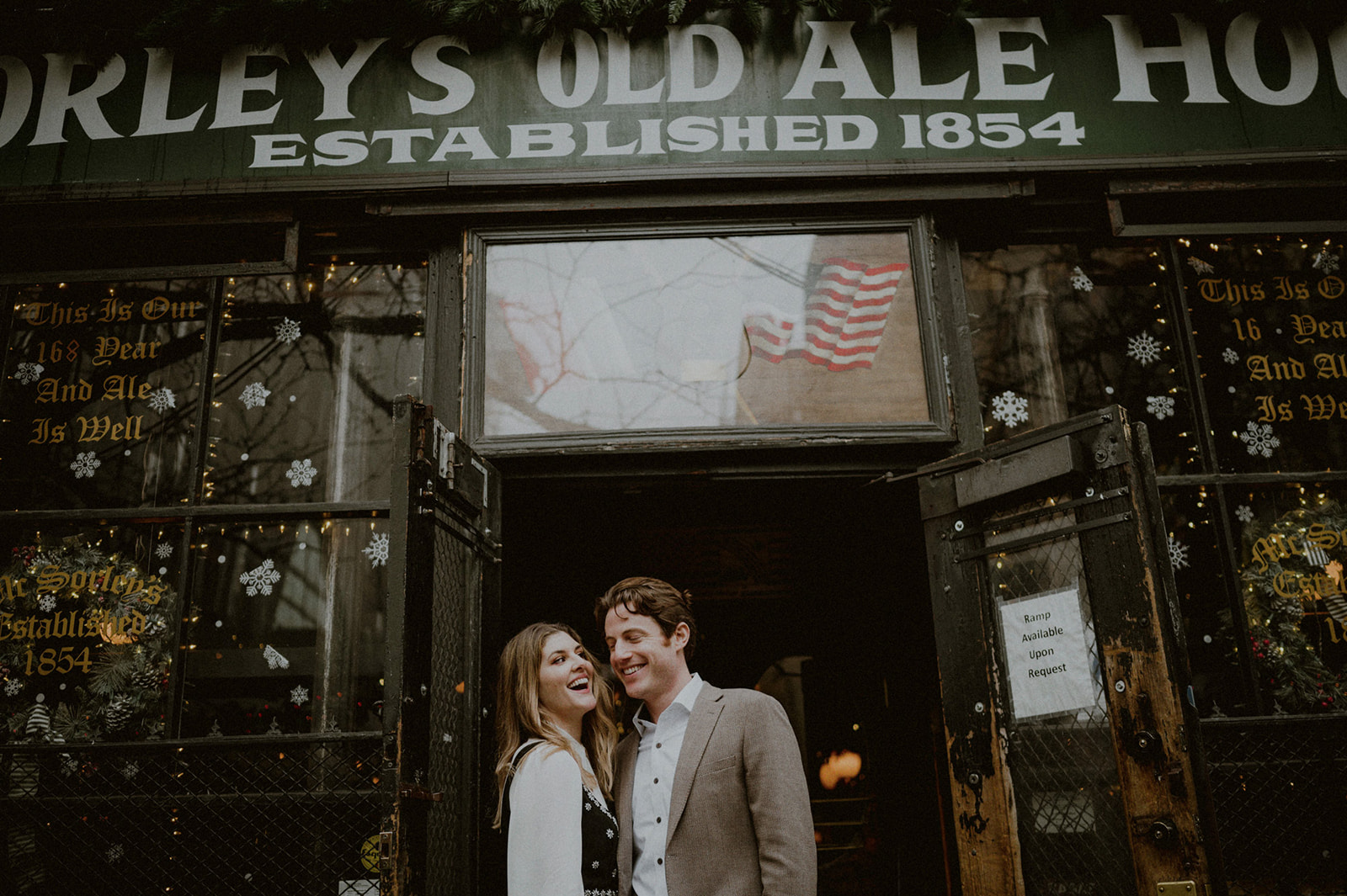 couple smiling outside of mcsorley's pub in nyc to celebrate their city hall elopement