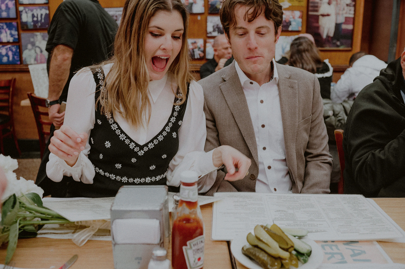 couple looking at the katz deli menu with an exaggerated expression