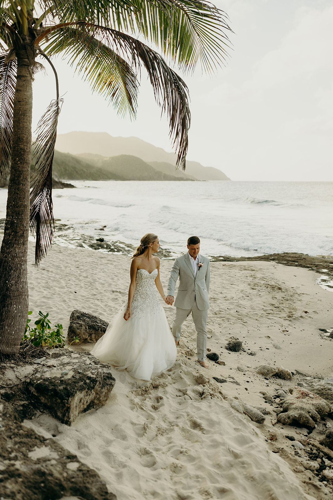 Bride and groom under palm trees at island elopement