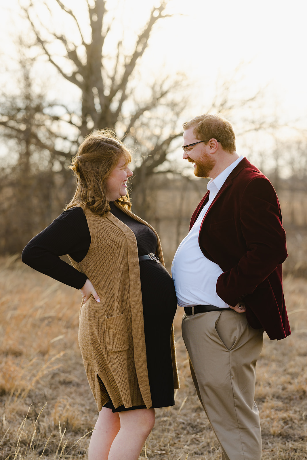 Comparing belly bumps for a wife and husband that are expecting a newborn baby during their winter maternity session