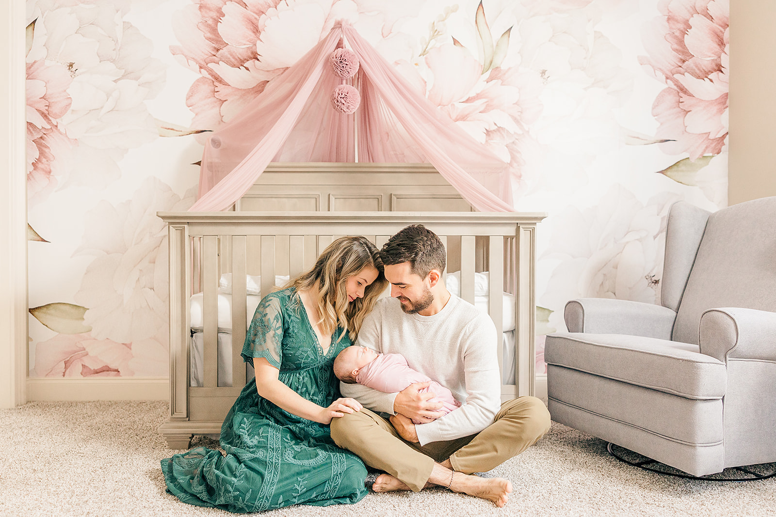 mauve and green newborn photography session mom and dad holding newborn girl