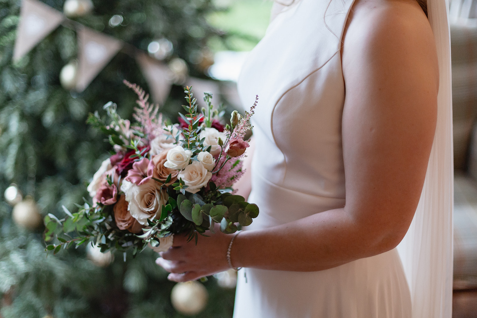 Bride and her bouquet with christmas tree in the background - Cairns Farm Estate