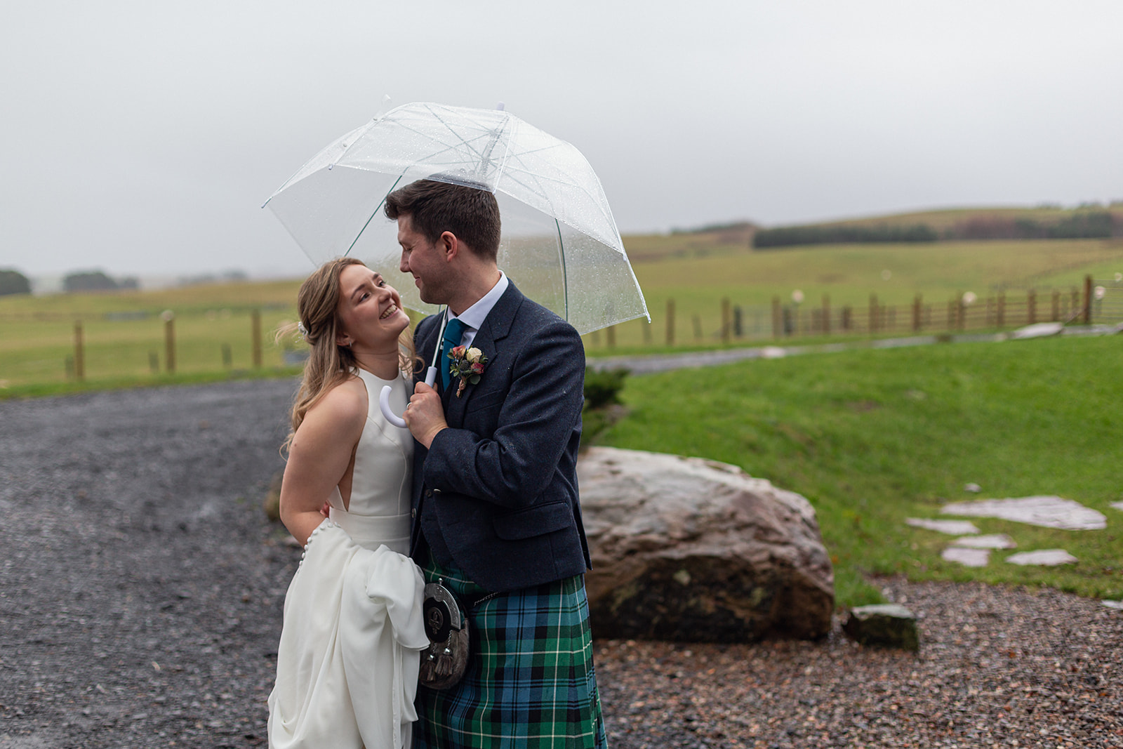 wedding couple in the rain under an umbrella - Cairns Farm Estate
