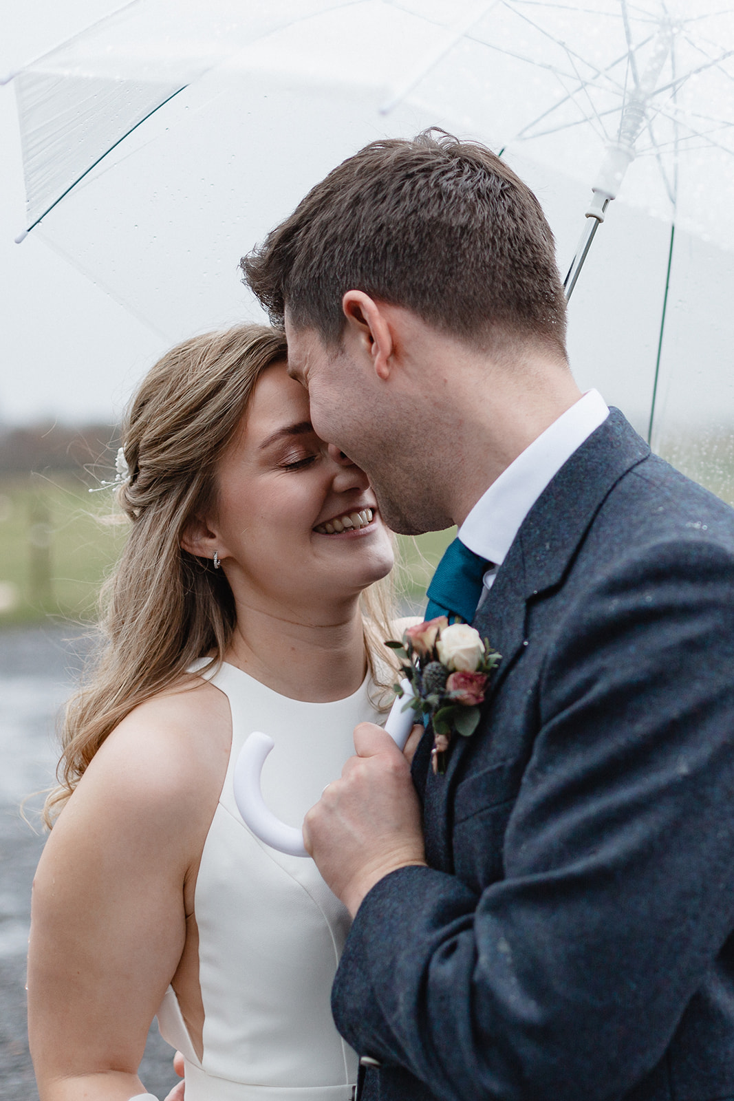 wedding couple in the rain under an umbrella at Cairns Farm Estate Silo
